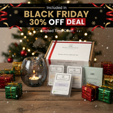 Wax Company gift set with candles and small boxes in front of a decorated Christmas tree.