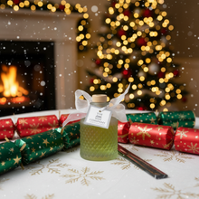 Christmas-themed setting with a bottle of wax, Christmas tree, and fireplace.