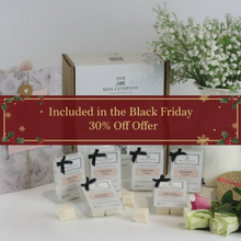 A collection of wax melt cubes from The Wax Company, displayed in front of their packaging. The cubes are white and there are labels in front of them with black text.