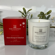 Candle and packaging of The Little Wax Company with clove orange & cedarleaf fragrance on a reflective surface.