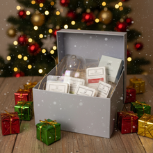 Gift box with tea bags in front of a decorated Christmas tree